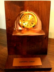 Galbano de escritorio, casco minero cobrizado con reloj sobre base de madera de Raulí , incluye placa grabada. 